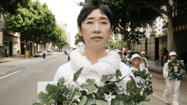 <b>Mourning Ms. Wang Yifei</b> holds a wreath to mourn her sister who was killed in a Chinese labor camp because she stood up for her faith in Falun Gong. Ms. Wang fled China to escape the same fate, and is shown here in a march in Los Angeles in 2016.
